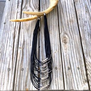 Black multi strand faux leather necklace with silver accents.